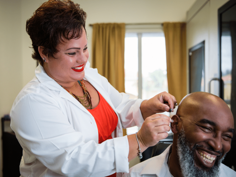 Dr. Michelle fitting a hearing aid