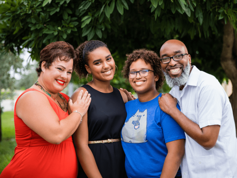 Dr. Michelle, a patient, and his family all together and smiling.